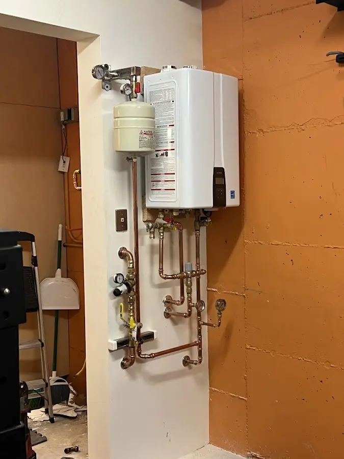 Plumbing technician inspecting water heater connections in Ben Lomond
